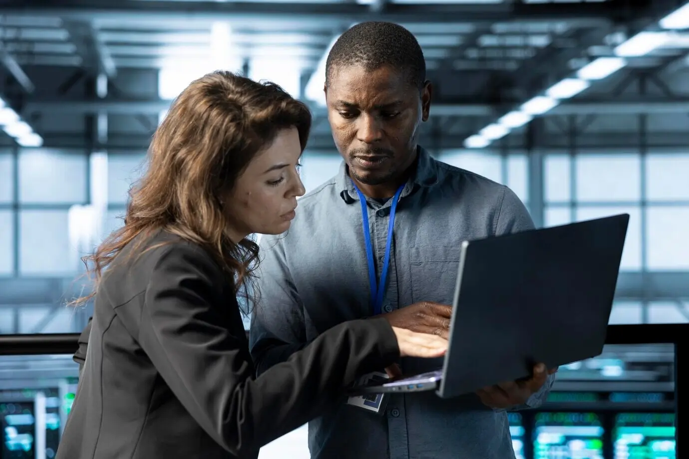 IT-специалисты серверного хаба разговаривают, используя ноутбук, чтобы отрегулировать настройки питания.